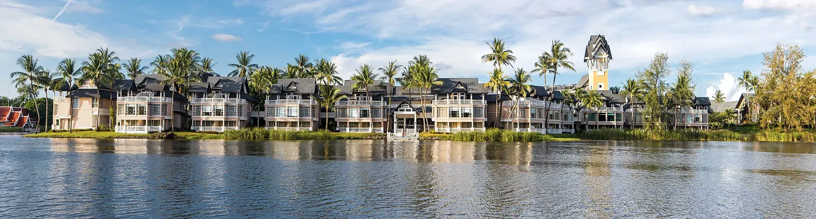 Resort buildings and palm trees beside the lagoon at Laguna in Choeng Thale, Phuket