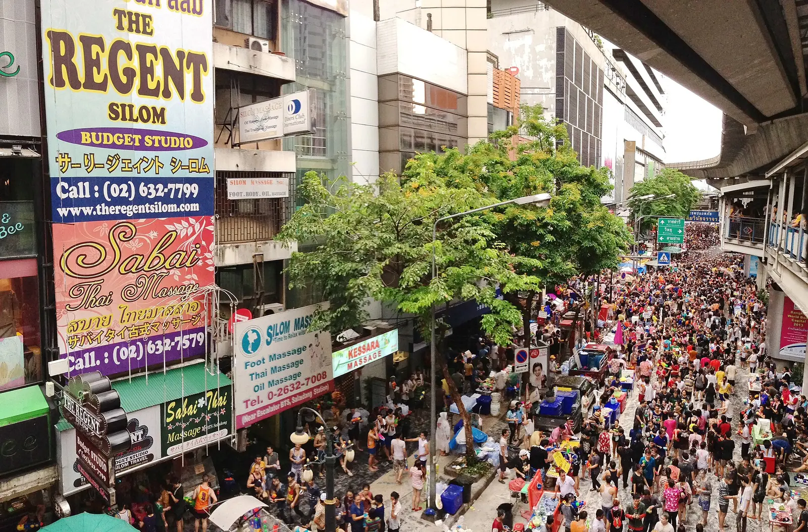 Crowds in colourful clothes filling Silom Road in Bangkok during Songkran